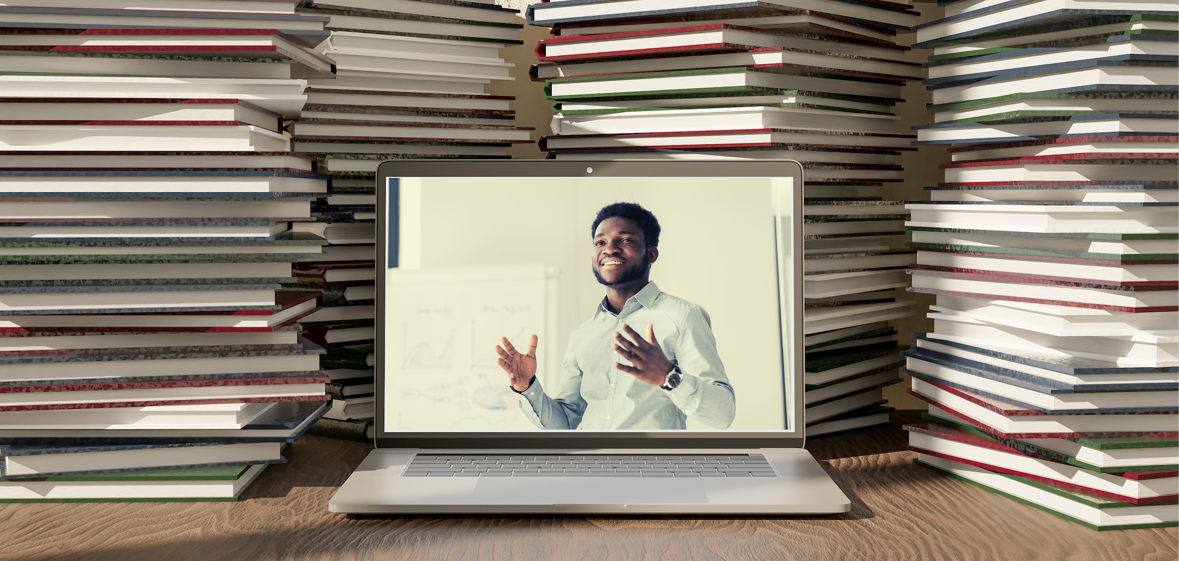 A laptop showing a course sitting in front of a stack of old books